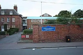 Photo d'un mur de briques rouges avec un passage permettant d'accéder à plusieurs bâtiments, eux aussi en briques rouges