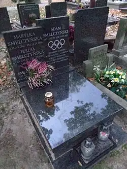 sépulture en marbre noir gravé avec les anneaux olympiques