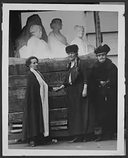 Photographie noir et blanc de la sculptrice Adelaïde Johnson accompagnée de deux femmes, devant son œuvre.