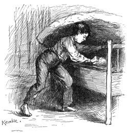 Le garçon soulève la paillasse d'un lit pour prendre un sac.