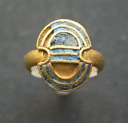 Bague en or en forme de double hache avec incrustations de lapis-lazuli