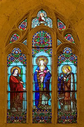 Vitrail du bas-côté avec le monogramme d'Henri Feur au pied de la représentantion de la Vierge à l'Enfant