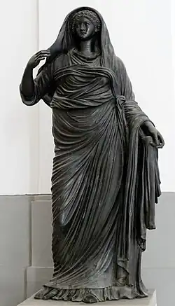 femme debout en robe et drapé, tête couverte