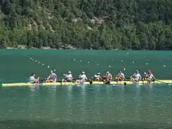 Neuf hommes se félicitent à l'arrivée de leur course dans leur bateau