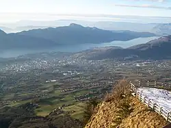 Vue plongeante sur une vallée occupée par un lac et une agglomération