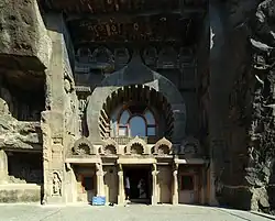 Ajantâ. Entrée du chaitya n° 9. Façade avec ouverture en fer à cheval (kudu) avec balcon. Le motif de la fenêtre chaitya se répète dans les arcs au-dessus du linteau.