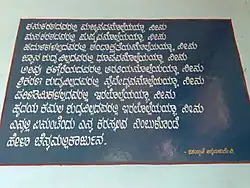 Photo d'un tableau noir sur lequel est calligraphié un poème en langue kannada