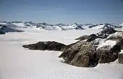 Un paysage neigeux avec des montagnes rocheuses.