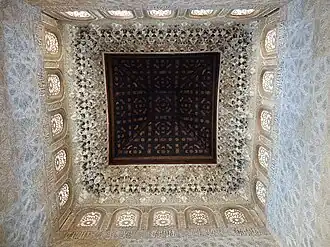 Intérieur de la chambre principale, avec décoration en stuc sculpté le long des murs et plafond en coupole en bois
