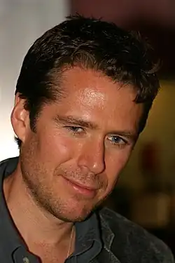 Alexis Denisof interprète Sandy Rivers.