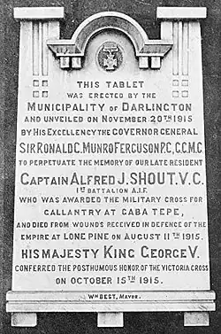 Photographie en noir et blanc représentant une plaque commémorative.