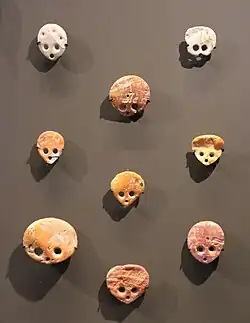 Amulettes ou pendeloques, disques en coquillages perforés de trous, formant des visages humains. Les trous étaient incrustés.