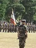 Colonel Christophe Launois devant le drapeau du 2e de marine.