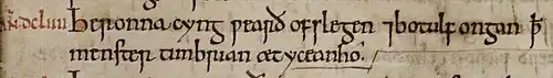 Gros plan sur un manuscrit : deux lignes de texte à l'encre noire précédées d'une année en chiffres romains à l'encre rouge