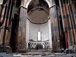 Une photo de l'intérieur de la cathédrale, les deux personnes présentes en bas à droite illustrent la taille de l'édifice.
