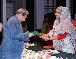 Une femme reçoit des livres d'un homme en face d'elle.