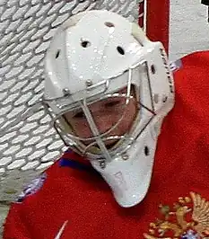 Un visage casqué penché vers le bas.