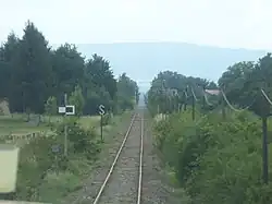 Pancarte mi blanche et mi noire vue le long d'une voie ferrée.