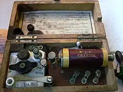 Vue de la pile, d'une bobine permettant de régler l'intensité du courant (voir les explications d'un système similaire sur ce site) et des trois bornes.