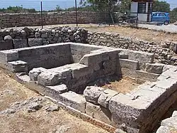 photographie : ruines de murs formant un bâtiment rectangulaire divisé en son milieu
