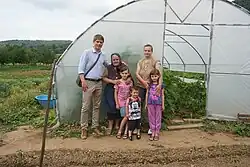 Arnaud Gouillon with his family from Kosovo in front of a greenhouse donated by the French humanitarian organization "Solidarity for Kosovo"