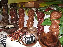 Photo de statuettes de tikis en bois et d'autres objets artisanaux.