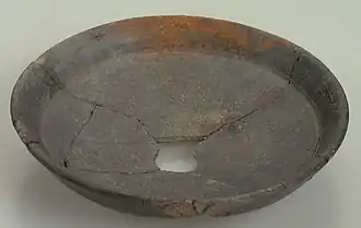 Assiette fragmentaire de couleur marron.