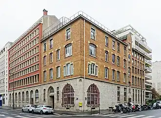Façade en briques rouges du siège de l'association, un immeuble de cinq étages à Paris.