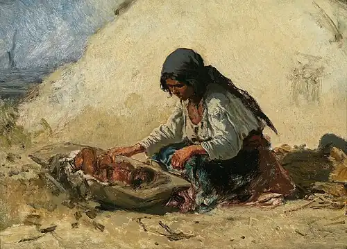 Tzigane lavant un bébé dans une baignoire en bois.