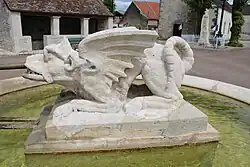 Vue latérale: les ailes de dragon et les pattes de griffon.