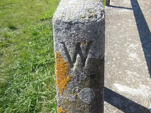 «&nbsp;W&nbsp;», initiale de Westminster / Woolsack, gravée sur la rampe du ponton