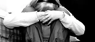 Photo noir et blanc d'une adolescente avec la tête entre les genoux