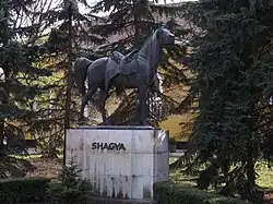 Statue d'un cheval harnaché, vu de profil.