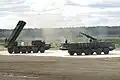 Un BM-30 de l'armée russe, à gauche, avec son véhicule tandem de rechargement, à droite.