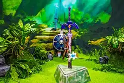 Une épée rouillée plantée dans un décor ressemblant à une forêt féerique.