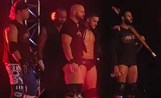 Plusieurs catcheurs faisant leur entrée.