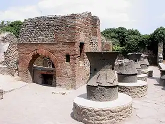 Meules constituées de deux éléments en lave volcanique.Boulangerie de Pompéi.