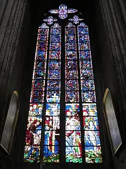 Photo de la baie 51 montrant des vitraux anciens en partie supérieure et plus récents sur le registre inférieur