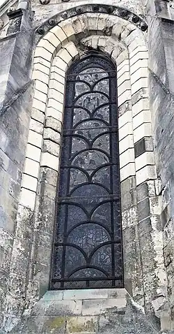 Baie de pierre en arc légèrement brisé avec une verrière.