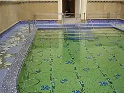 Photographie en couleurs d'un ancien bassin thermal public.