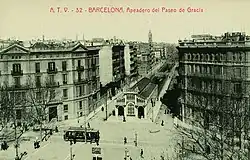 Photographie ancienne de l'intersection d'une avenue avec un boulevard. Un bâtiment moderniste fait l'angle.