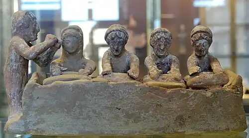 Pétrissage (époque gréco-romaine), les ouvrières travaillent en cadence, au son d'un joueur de flûte. Terre cuite béotienne, vers 500 av. J.-C., Thèbes (Grèce).