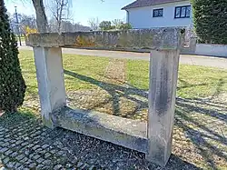 Un banc en gré des Vosges disposant de deux traverses superposées, située au milieu du village d'Altorf.