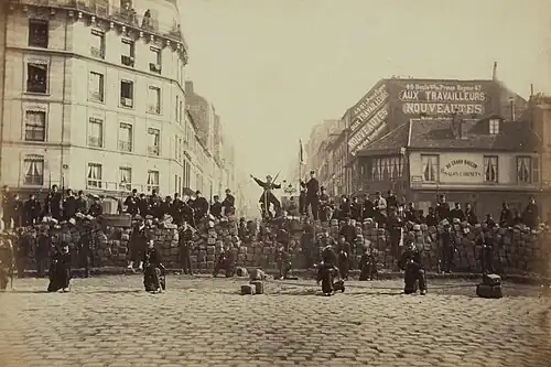Photographie montrant des soldats en armes sur une barricade.