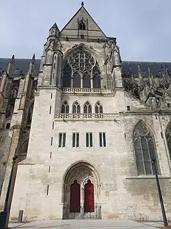 Façade sud du grand transept avec une grande rosace à quatre branches, les quatre petites fenêtres du scriptorium et le portail composé de deux vantaux rouges en bois.