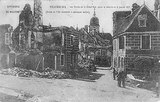 Carte postale ancienne montrant des bâtiments détruits dans un village.