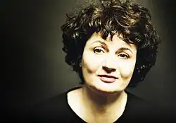 Visage rond d'une femme, regardant sur le côté. La lumière est surexposée sur sa peau.