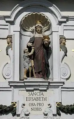 Statue figurant sainte Élisabeth de Hongrie distribuant des aumônes.