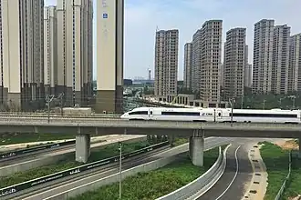 Urbanisation dense, architecture de grande hauteur (25-30 étages). Voies rapides. LGV Pékin - Canton, 2&nbsp;298&nbsp;km à 300&nbsp;km/h, ici/ Zhengzhou, ligne ouverte en 01-2013.
