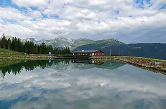 Bergeralm&nbsp;(de), avec sa réserve d'eau pour les canons à neige et un restaurant à l'arrière plan, à Steinach am Brenner. Aout 2021.